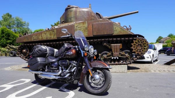 The photo shows the Harley and a Sherman tank at the Omaha Beach Memorial