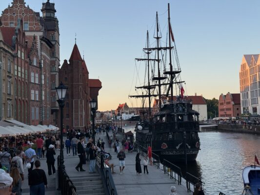 Mit der CVO Street Glide 2025 quer durch Polen Hafenansicht mit historischem Schiff.