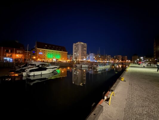 Mit der CVO Street Glide 2025 quer durch Polen Hafen bei Nacht mit beleuchteten Gebäuden