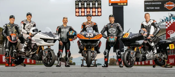 a group of men standing next to motorcycles